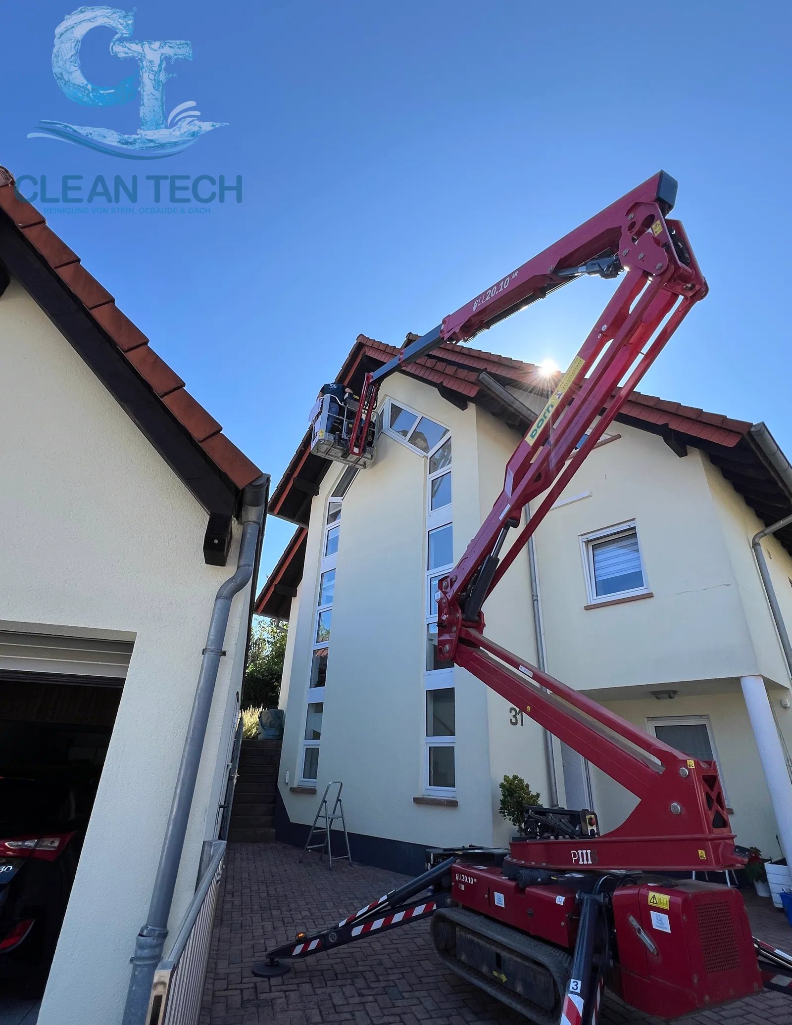 Fensterreinigung mit eigener Raupen-Hebebühne an einem Wohnhaus
