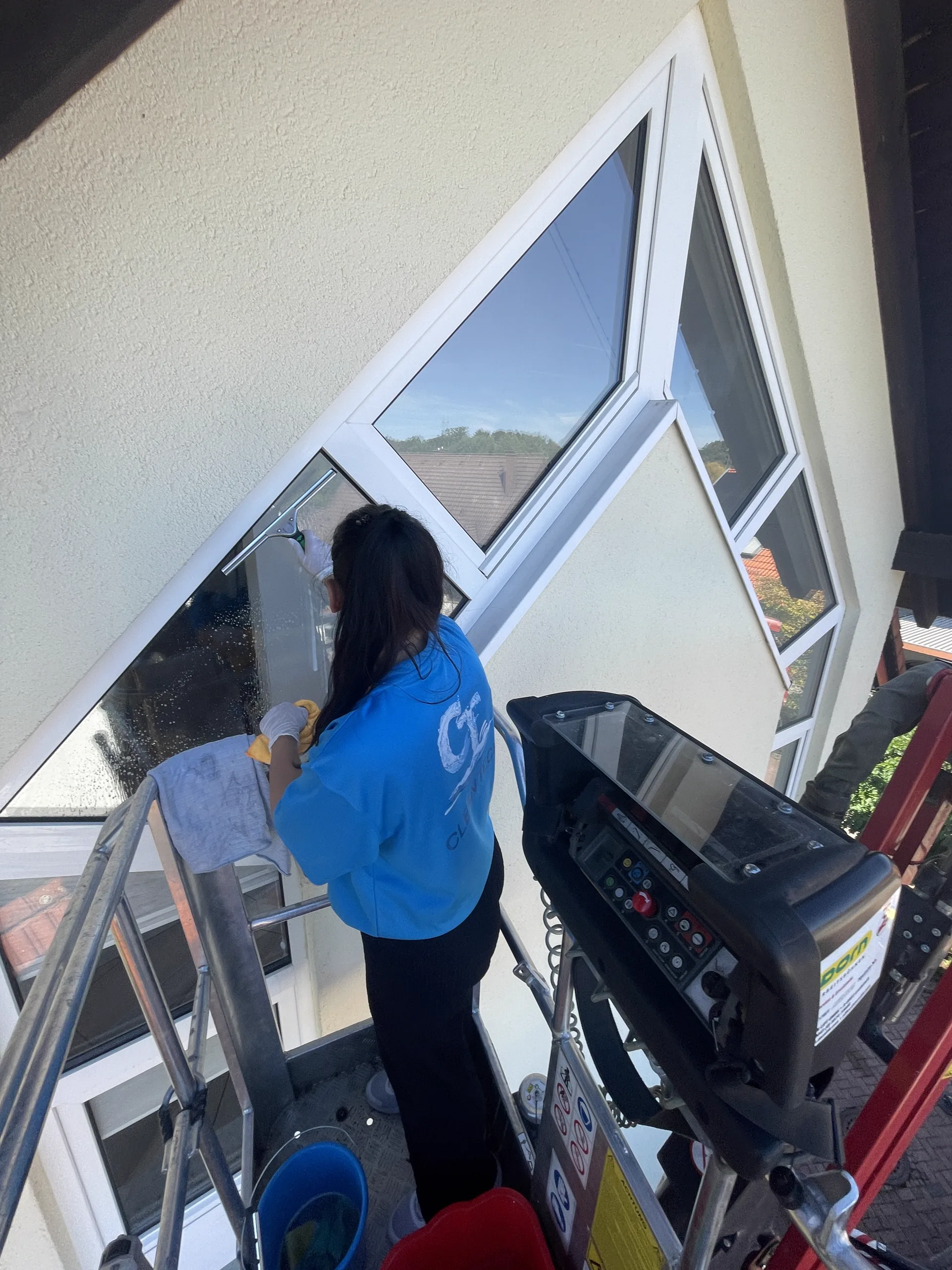 Zwei Clean-Tech-Mitarbeiter reinigen hohe Giebelfenster